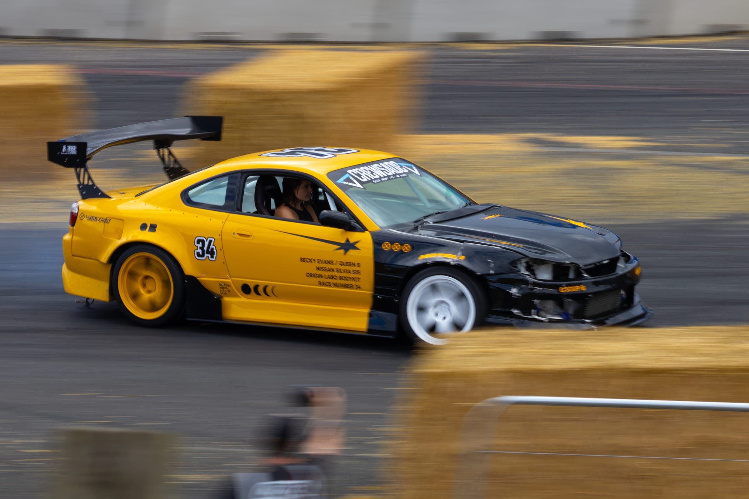 A drift car with a roof-mounted lamp pod turning in, Gravity 2026