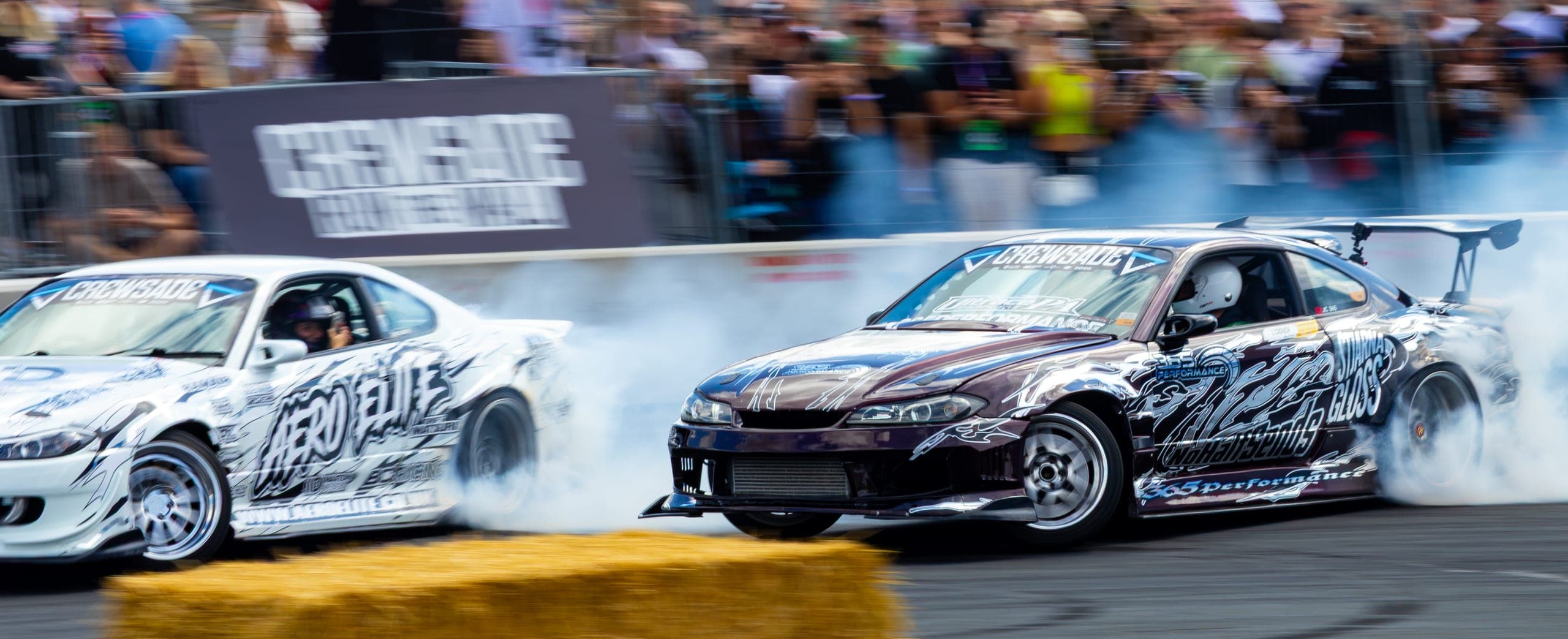 A drift car running hard up against the spectator fence, Gravity 2026