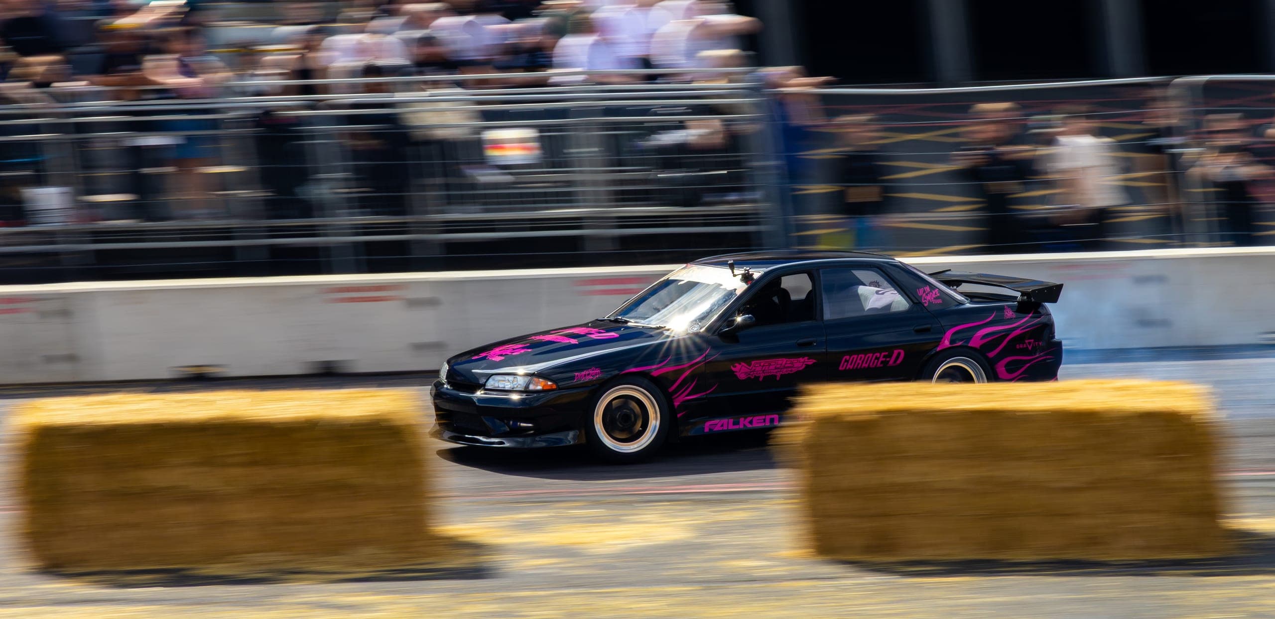 A panning shot of a drift car against a blurred barrier, Gravity 2026