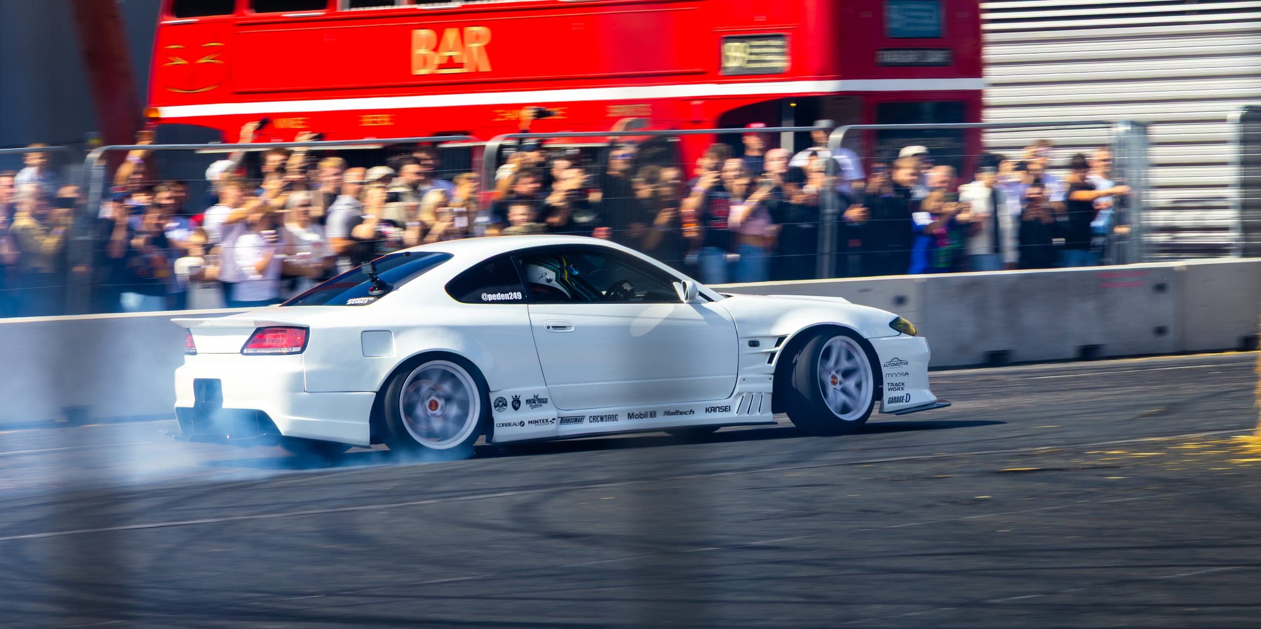 A white widebody drift car sideways on the tarmac, Gravity 2026