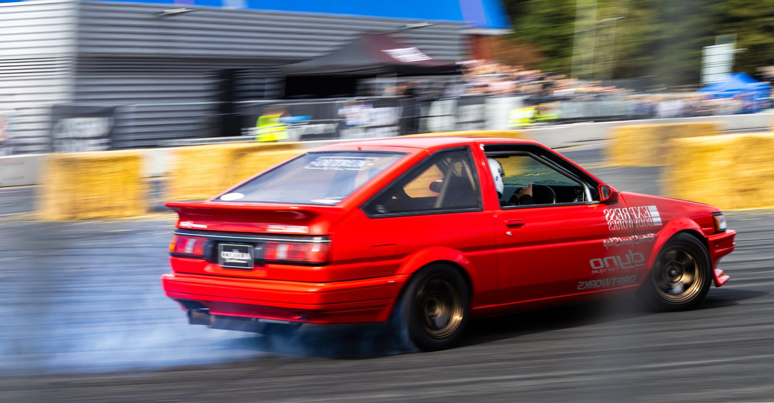 A red hatchback sliding through its own smoke, Gravity 2026