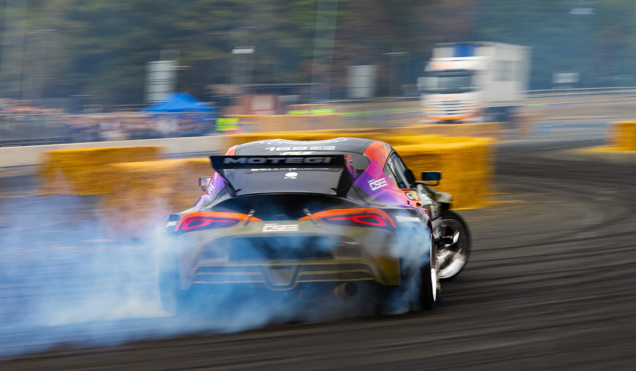 A winged drift car almost lost in tyre smoke, Gravity 2026