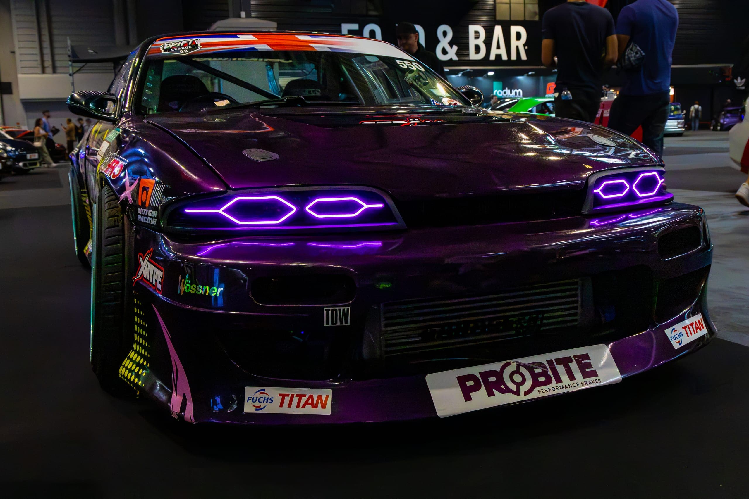 A purple show car photographed head-on under the hall lights, Gravity 2026