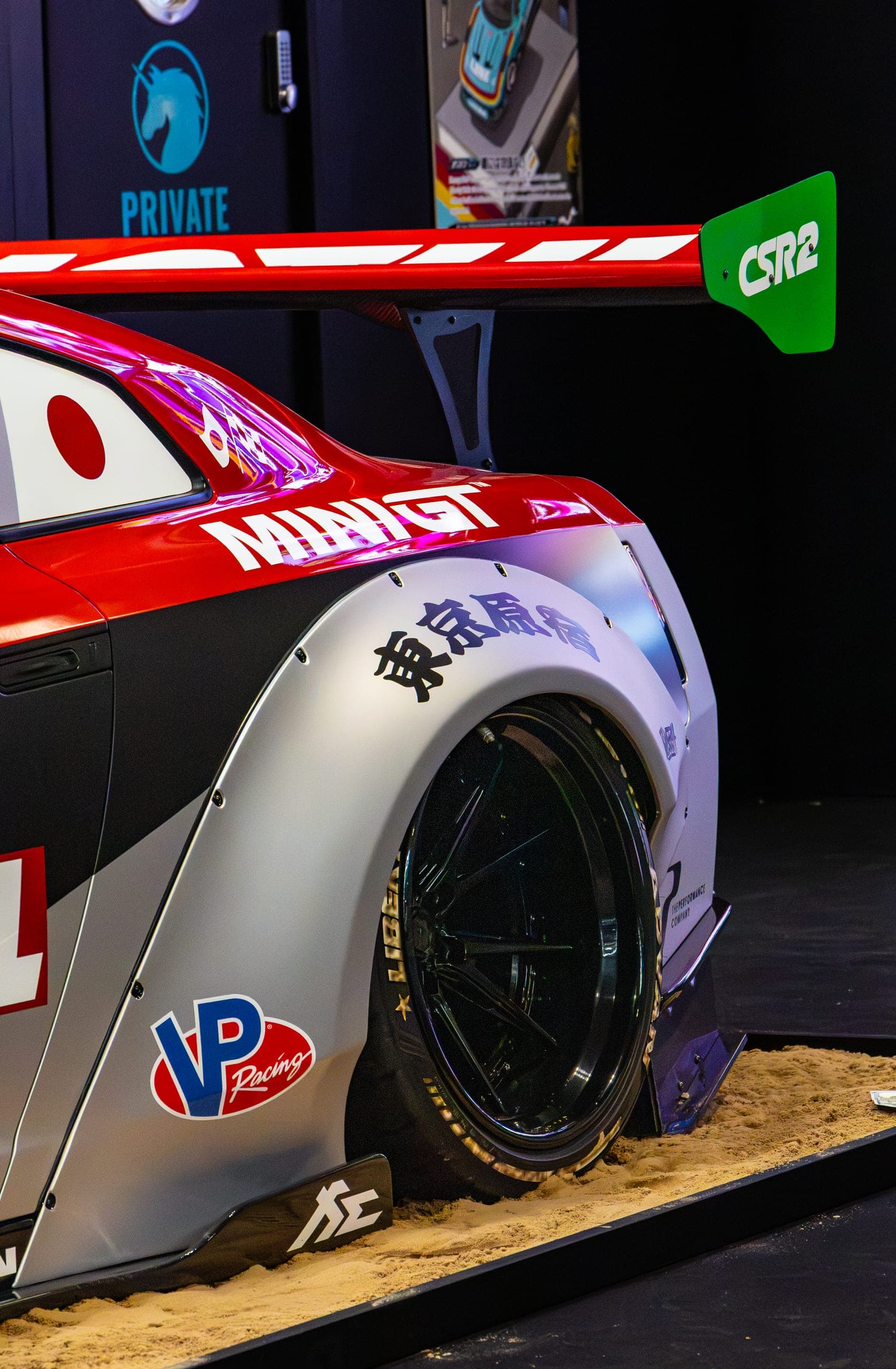 A Japanese-liveried race car on the stand, Gravity 2026