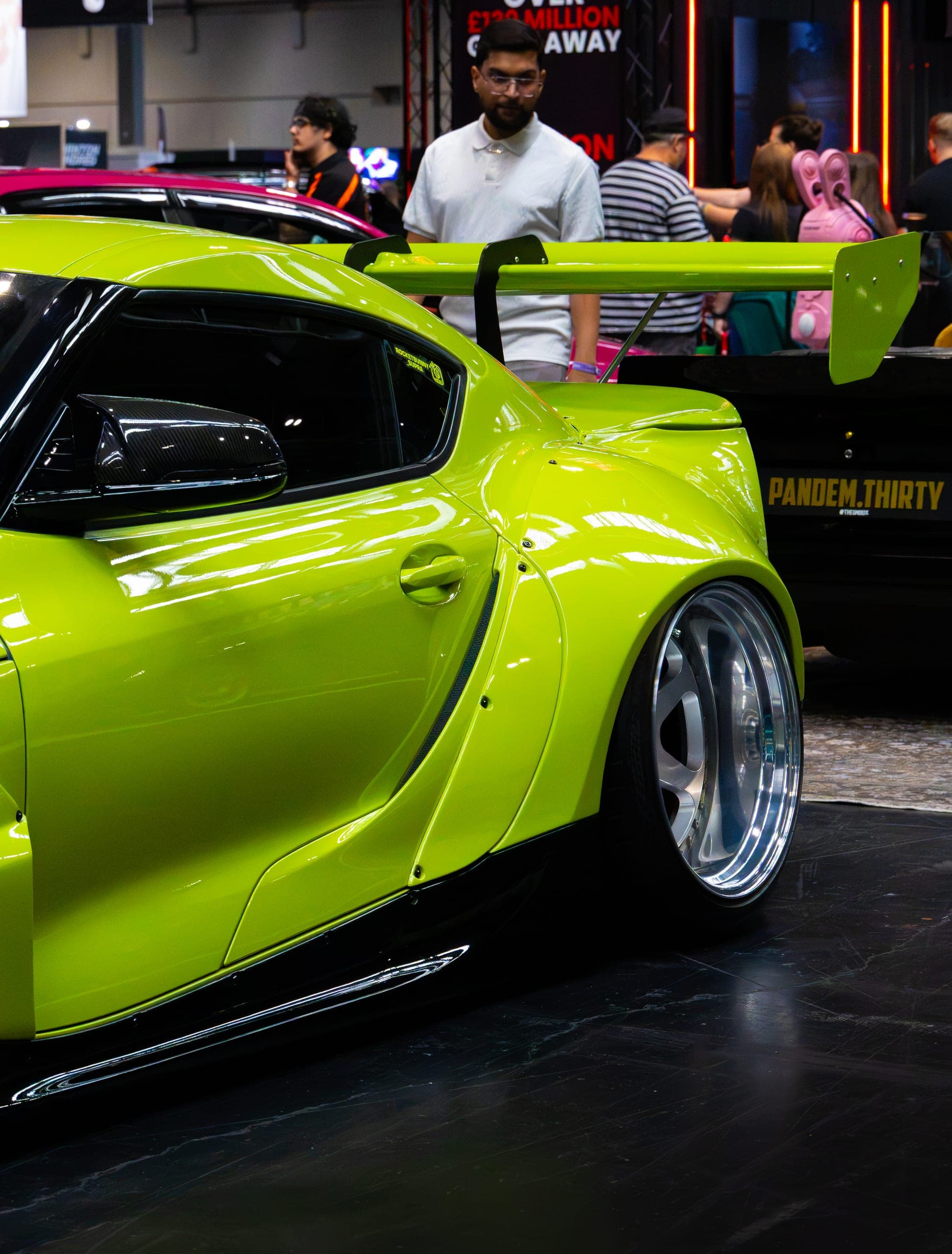 A lime green widebody coupe on the show floor, Gravity 2026
