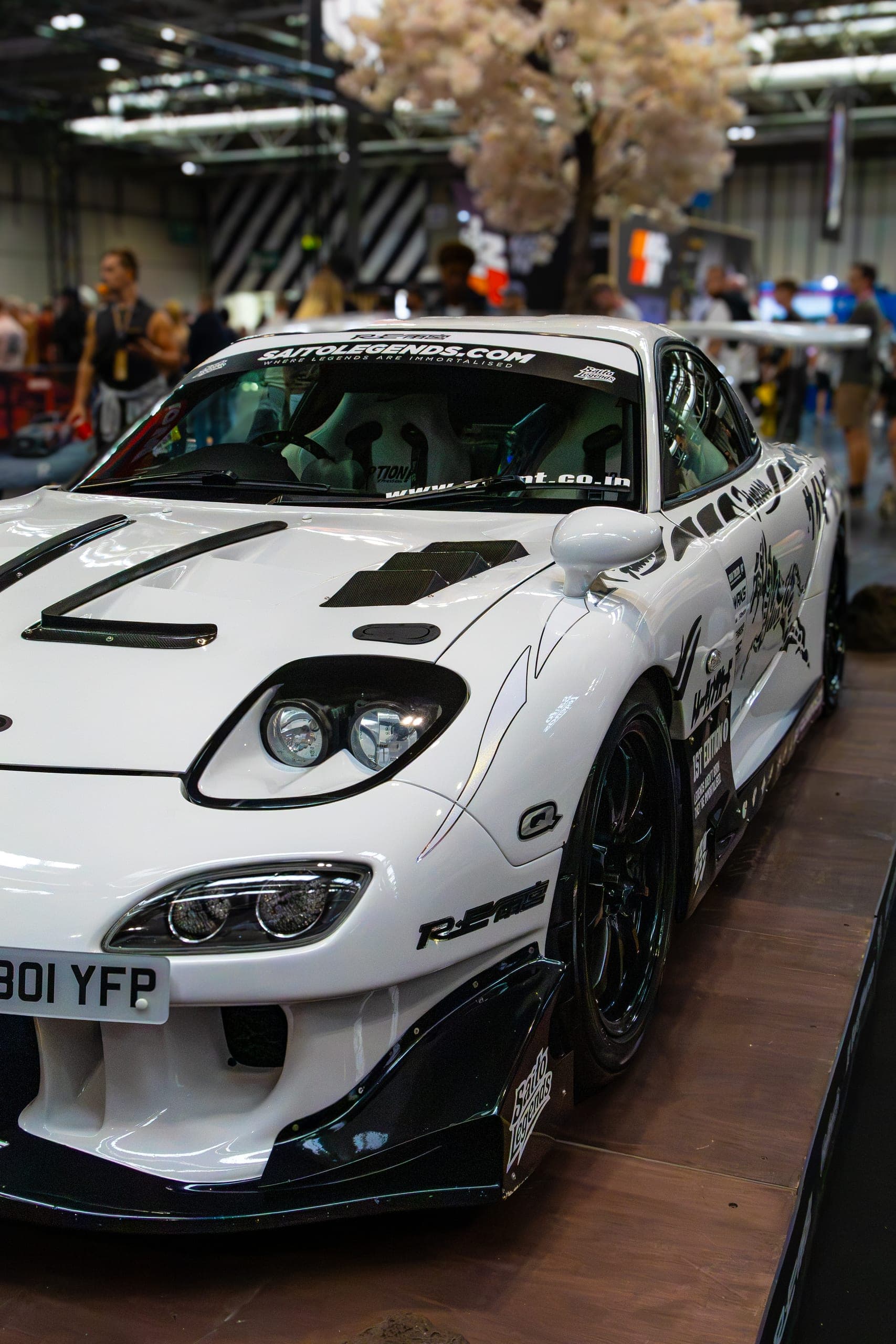 A white widebody coupe on the exhibition floor, Gravity 2026