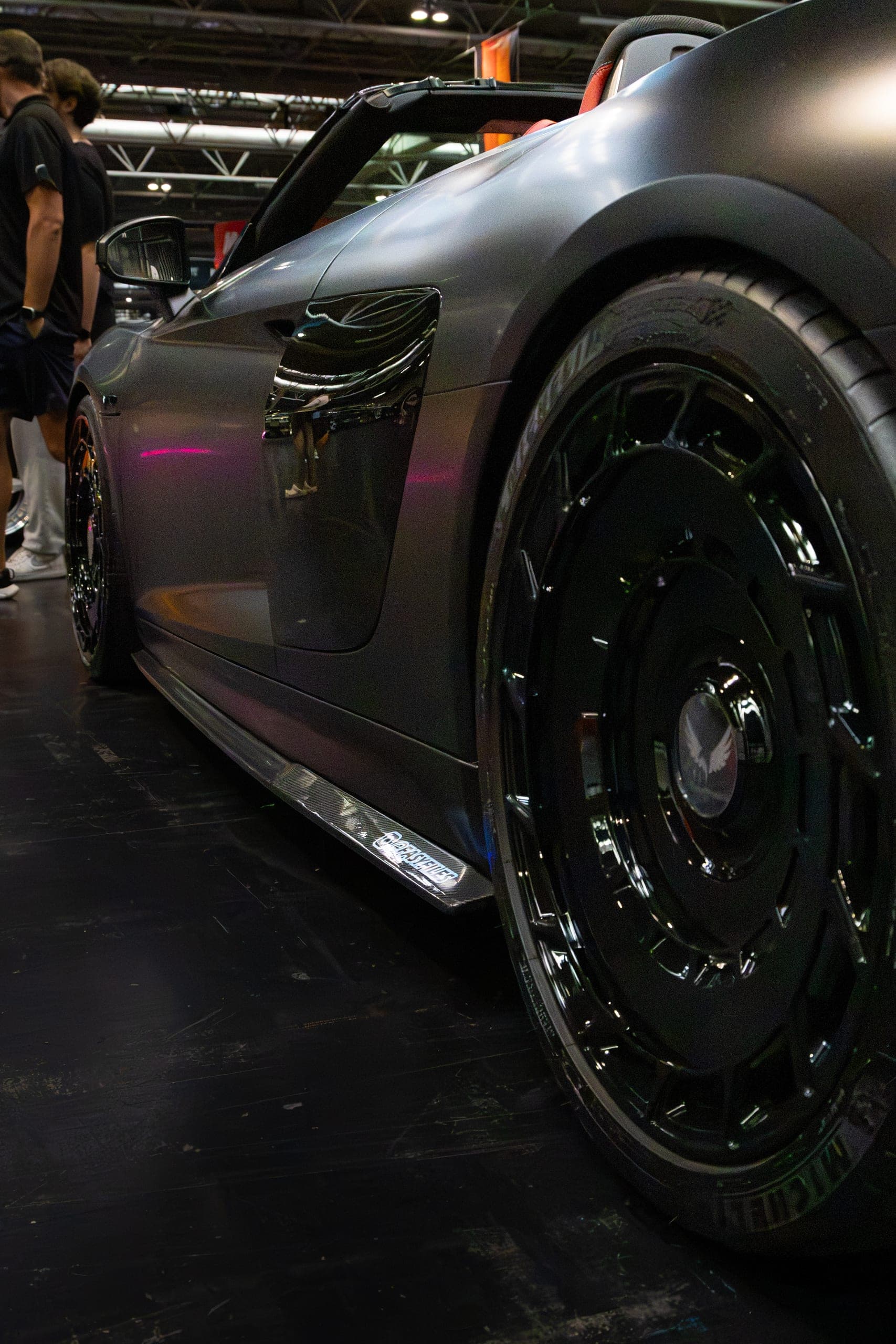 A black wheel and side skirt in low light, Gravity 2026